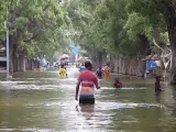 En esta imagen tomada de vídeo, los residentes se mueven a través de las aguas de la inundación en una calle de la ciudad de Beledweyne, en Somalia, el domingo 19 de noviembre de 2023.