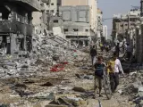 Ni&ntilde;os palestinos caminan sobre las ruinas de Gaza.