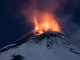 Una lluvia de fuego sobre la nieve es la magnética imagen que nos deja el volcán Etna, en Italia. La lava cae por su blanca ladera nevada en plena noche, con continuas explosiones de hasta cuatro kilómetros y medio de altura.