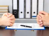 Hands of wife and husband signing divorce documents or premarital agreement at the lawyer's office