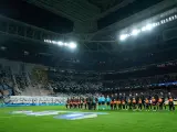 Jugadores del Real Madrid y del Nápoles escuchan el himno de la Champions en el Santiago Bernabéu.