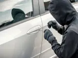 Un ladrón en el proceso del robo de un coche.
