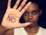 Una mujer muestra su mano con la palabra NO.