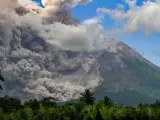 Un denso humo se eleva durante una erupción del Monte Merapi, el volcán más activo de Indonesia, visto desde el pueblo de Tunggularum en Sleman el 11 de marzo de 2023.