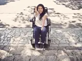 Una joven en silla de ruedas ante unas escaleras.