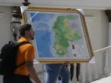 Un hombre lleva el nuevo mapa de Venezuela con el territorio de Esequibo, una gran franja de tierra que es administrada y controlada por Guyana pero reclamada por Venezuela.