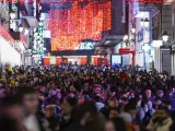 Cientos de personas pasean por el centro de Madrid iluminado con motivo de las fiestas navideñas.