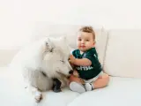 Un bebé junto a su perro.