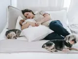 Una madre durmiendo junto a su beb&eacute; y sus perros.