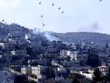 Columnas de humo sobre edificios residenciales en el campo de refugiados de Yenín durante una incursión de las fuerzas israelíes, cerca de la ciudad de Yenín, en Cisjordania, el 12 de diciembre de 2023.