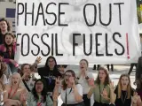 Activistas se manifiestan con un cartel que pide eliminar gradualmente los combustibles fósiles en la COP28, el 12 de diciembre de 2023, en Dubai, Emiratos Árabes Unidos.