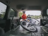 Una ciclista saca su bicicleta del malero del coche.