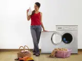 Una persona poniendo la lavadora.