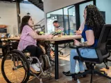 Una trabajadora con discapacidad en una reunión junto a sus compañeros.
