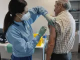 Una sanitaria administra la vacuna frente a la gripe y la covid a un hombre en Andalucía.