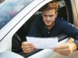 Un conductor revisa la documentación de su vehículo donde aparece el número VIN.