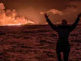 Un vecino de la zona observa con los brazos levantados la erupción del volcán islandés, a tres kilómetros de distancia en la península de Reykjanes, cerca de la localidad de Grindavik.