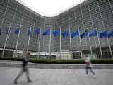 Banderas de la Unión Europea ondean al viento mientras los peatones caminan por la sede de la UE en Bruselas.