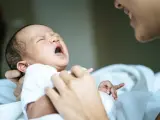 Un bebé recién nacido llora en los brazos de su madre