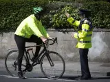 Un policía para a un ciclista para realizarle el test de alcoholemia. Covid 19 Sunny weather on the bank holiday karen Morgan 03/05/20