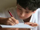 Imagen de recurso de un niño escribiendo una carta.