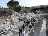Libaneses se reúnen frente a una casa que fue destruida por un ataque aéreo israelí el martes por la noche, en Bint Jbeil, en el sur del Líbano.