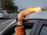 Un conductor coloca la luz de emergencia en la parte superior de sus coche.