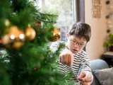 Un niño con síndrome de Down decorando un árbol navideño