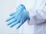 Un médico se coloca los guantes.