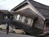 Una mujer observa una vivienda destruida tras el terremoto.