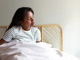 Una mujer levantándose de la cama.