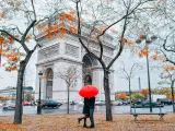 Pareja bajo un paraguas en el Arco de Triunfo de París.