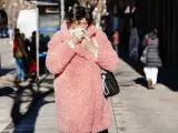 Una mujer se limpia la nariz mientras pasea por una calle de Madrid, este 5 de enero de 2024.