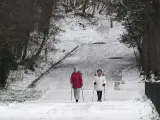 Dos mujeres caminan por el pavimento helado a las afueras de París.