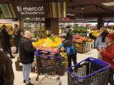 Compradores hacen cola y observan productos en un supermercado de Barcelona.