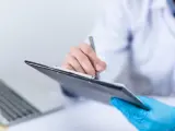 Un médico utiliza un dispositivo electrónico durante una consulta.