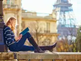 Turista en París leyendo un libro.