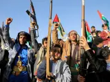Combatientes hutíes blanden sus armas durante una protesta tras los ataques de las fuerzas estadounidenses y británicas en Saná.