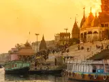 Scenic view from the river on Ghat with crowd. Sunset colores the temples. Varanasi known as Banaras is the holies city in India. It is on the banks of the river Ganges where the special funeral ritual, cremation goes on for purifying and final releases of the spirit from the body.