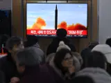 Un grupo de personas observa una pantalla de televisión que muestra un noticiario con imágenes de archivo de un ensayo de misil norcoreano, en una estación de ferrocarril de Seúl, el 14 de enero de 2024.