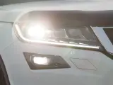 Un coche con las luces encendidas de día.