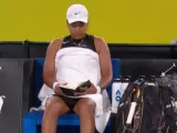Naomi Osaka leyendo durante su partido ante Caroline Garcia en el Open de Australia.