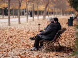 Una mujer de edad avanzada se sienta en un parque madrileño
