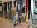 Un usuario accede a un vagón del metro de Sevilla con su patinete.