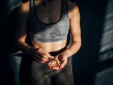 Mujer come un snack saludable tras entrenar.