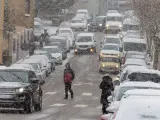 Varios coches circulan mientras nieva en Soria.