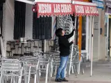Una camarera levanta el toldo de un bar en Madrid.