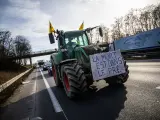 Un agricultor francés conduce su tractor con un cartel donde se puede leer "La muerte está en el campo", mientras avanza por una autopista hacia el aeropuerto de París-Charles de Gaulle.