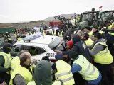 Agricultores mueven coches de la Guardia Civil para acceder a Pamplona, este jueves.