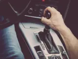 Un conductor acciona la caja de cambios automática de su coche.